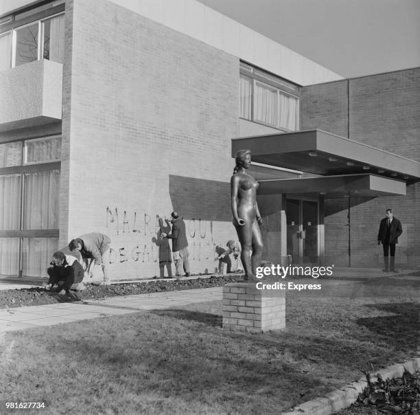 People cleaning the wall of the Maison française d'Oxford, after being vandalised, Oxford, UK, 19th November 1967.