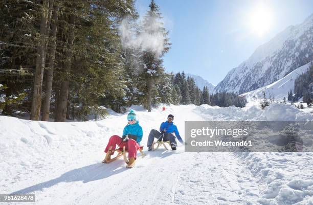 couple sledding in snow-covered landscape - sledge fotografías e imágenes de stock