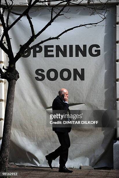 Man pases by an advertising a new store in the center of Sofia on March 31, 2010. Bulgaria's government adopted on March 31 a package of 60...