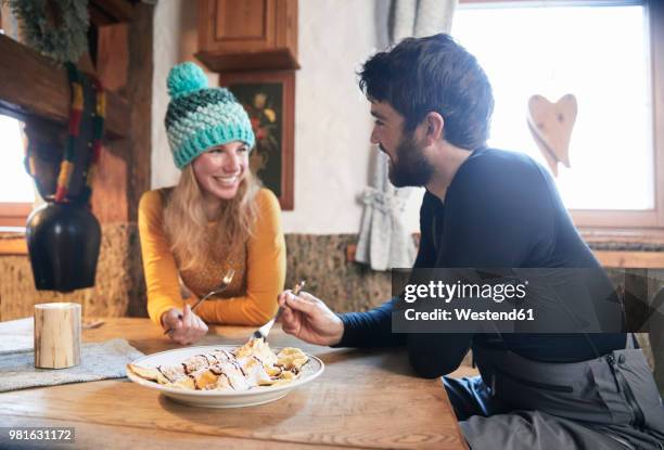 happy couple eating in rustic mountain hut - hut interior stock pictures, royalty-free photos & images