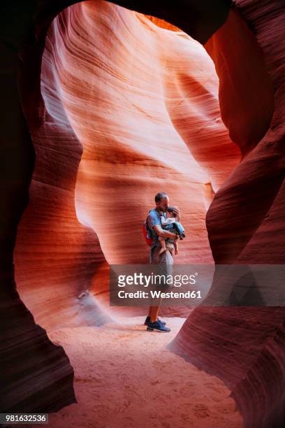 usa, arizona, father with baby on a baby carrier visiting antelope canyon - 庇護者 ストックフォトと画像