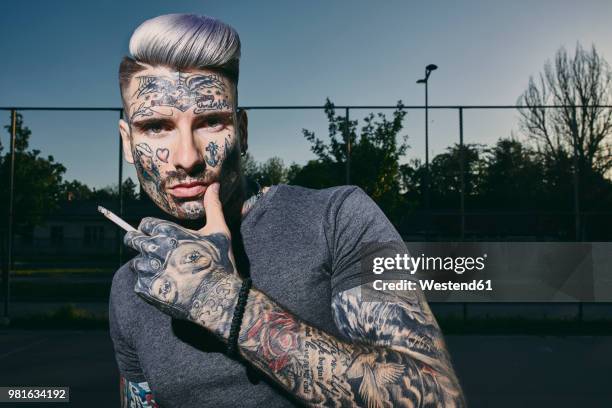 portrait of tattooed young man smoking a cigarette - anti smoking bildbanksfoton och bilder