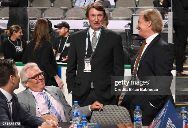 Vice Chairman Wayne Gretzky of the Edmonton Oilers speaks with general manager Glen Sather and assistant to the general manager Dave Maloney of the...