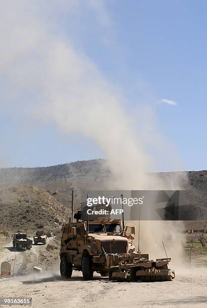 Military vehicle sweeps a road during a patrol in Sar Hawza district of Paktika province on March 31, 2010. A bomb attack in a crowded market in...