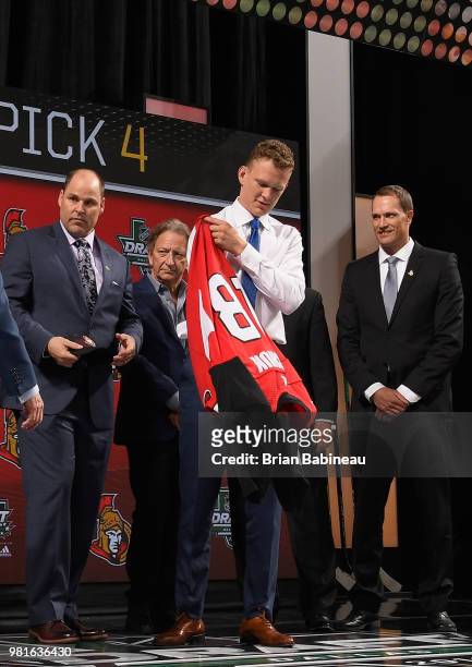 Brady Tkachuk puts on an Ottawa Senators jersey after being selected fourth overall by the Ottawa Senators during the first round of the 2018 NHL...