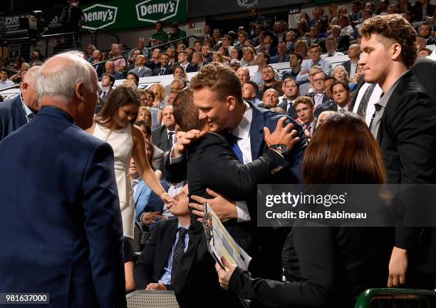 Brady Tkachuk, selected fourth overall by the Ottawa Senators, hugs a member of his group during the first round of the 2018 NHL Draft at American...