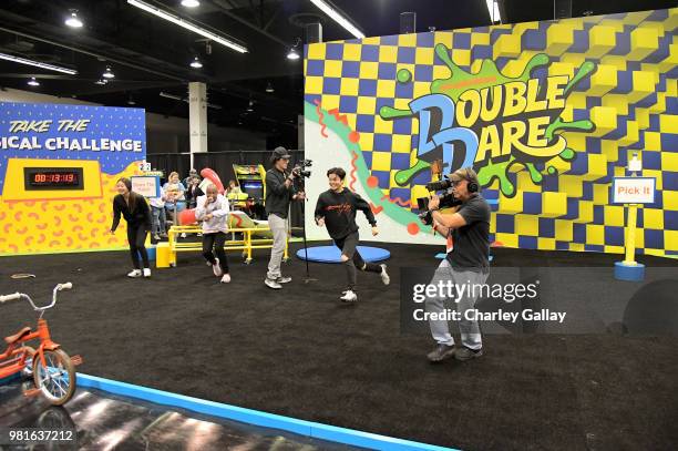 Olympian Ice Dancers Maia Shibutani and Alex Shibutani experience the Double Dare obstacle course at Nickelodeon's booth at 2018 VidCon at Anaheim...