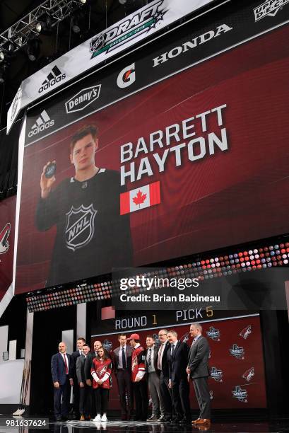 Barrett Hayton poses for a photo onstage after being selected fifth overall by the Arizona Coyotes during the first round of the 2018 NHL Draft at...