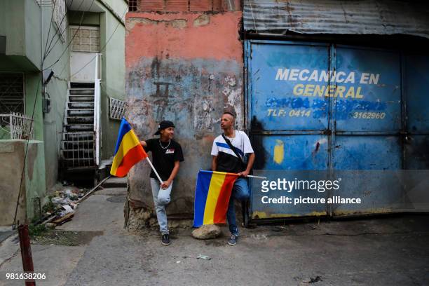 March 2018, Venezuela, Caracas: Supporters of opposition candidate Henri Falcon carrying national flags while waiting for a visit by Falcon to the...
