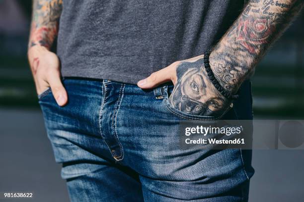 tattooed arms of a young man outdoors - hands in pockets fotografías e imágenes de stock