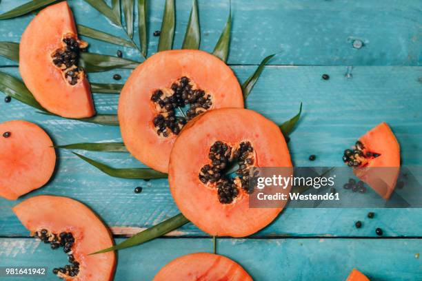 sliced papaya on blue wood - papaya stock pictures, royalty-free photos & images