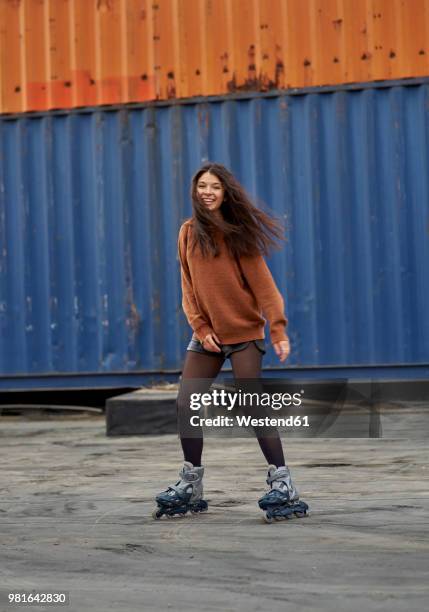 portrait of young inline-skater at industrial area - inline skating - fotografias e filmes do acervo