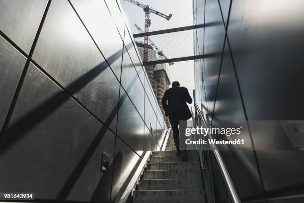 businessman walking on staircase in the city - person in suit construction stock pictures, royalty-free photos & images