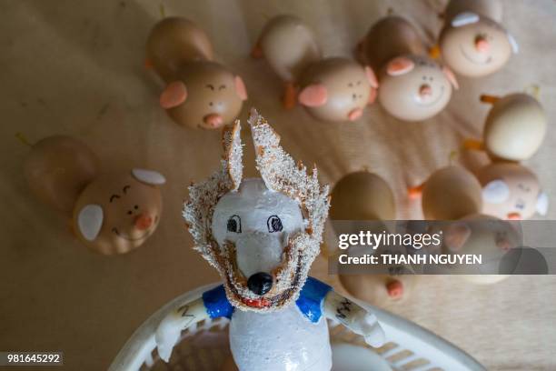 This picture taken on June 20, 2018 shows retired Vietnamese English teacher Nguyen Thanh Tam assembling eggshells as he creates a model of Zabivaka,...