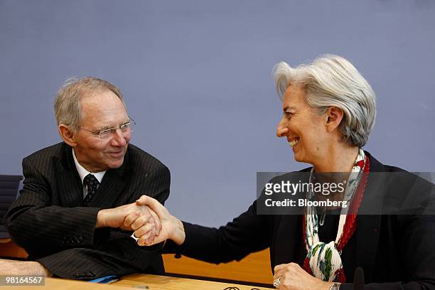 Wolfgang Schaeuble, Germany's finance minister, left, shakes hands with Christine Lagarde, France's finance minister, after a meeting of the German...