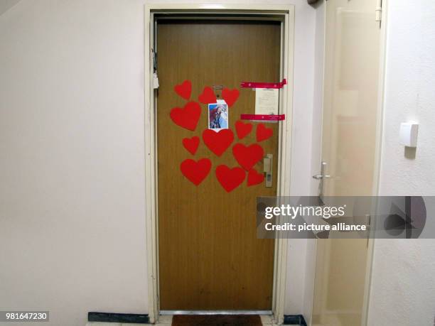 March 2018, France, Paris: Hearts, a photograph, and a police seal, glued to the door to the appartment of the 85-year-old Holocaust survivor...