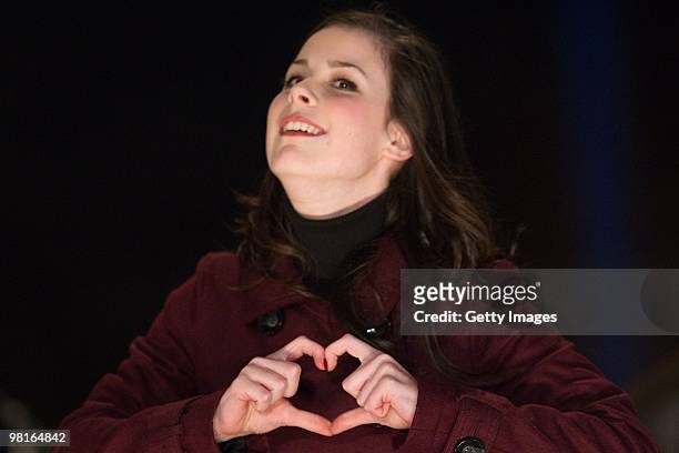 German singer Lena Meyer-Landrut forms a heart with her hands on stage during the 'TV Total Wok WM 2010' on March 19, 2010 in Oberhof, Germany.
