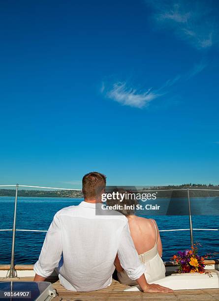 bride and groom sitting on edge of sailboat - inti st clair stock pictures, royalty-free photos & images