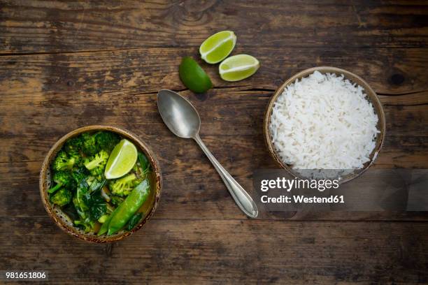 green thai curry with broccoli, pak choi, snow peas, baby spinach, lime and bowl of rice - green curry stock pictures, royalty-free photos & images