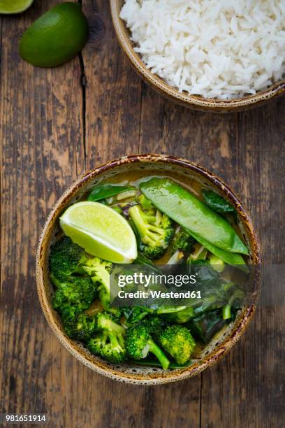 green thai curry with broccoli, pak choi, snow peas, baby spinach, lime and bowl of rice - fresh baby spinach stock pictures, royalty-free photos & images