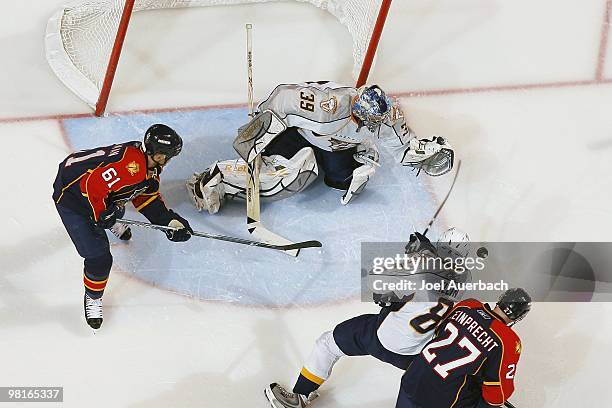 Goaltender Dan Ellis of the Nashville Predators guards the net as Cory Stillman of the Florida Panthers waits for a rebound on March 29, 2010 at the...