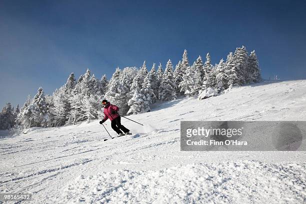 skiier heads down the run. - mont tremblant ski village stock pictures, royalty-free photos & images