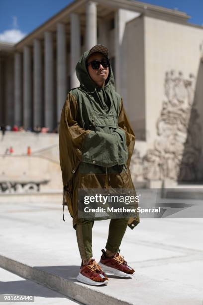 Guest is seen on the street during Paris Men's Fashion Week S/S 2019 wearing an army green coat with red sneakers on June 22, 2018 in Paris, France.