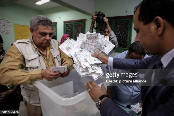 Election officials empty a ballot box before starting to count votes at the end of the third and final day of Egypt's presidential elections, at a...