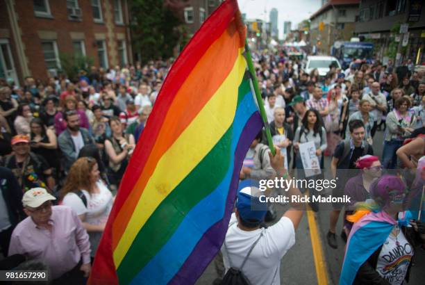 Man holds a PRIDE flag near the stage. The Trans rally and march has become a regular part of the final PRIDE weekend activities. Thousands gathered...