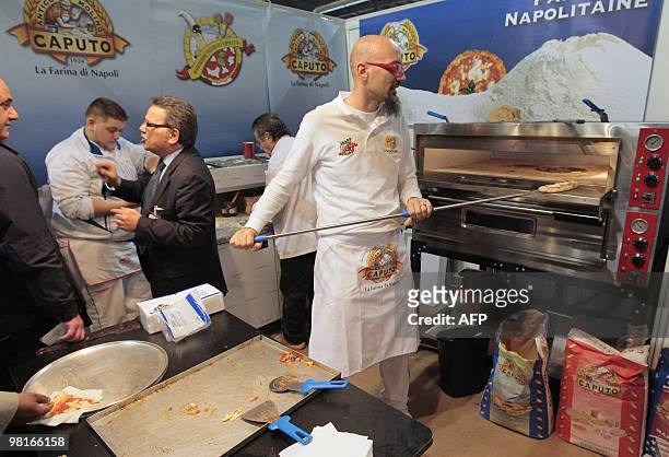 An exhibitor prepares pizzas on March 31, 2010 during the Pizza & Pasta expo, part of the "Foods & goods" fair at the Porte de Versailles exhibition...