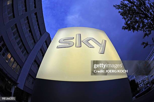 The logo of the pay-tv station "Sky" illuminates in front of the company's building in the southern German town of Unterfoehring, near Munich on July...