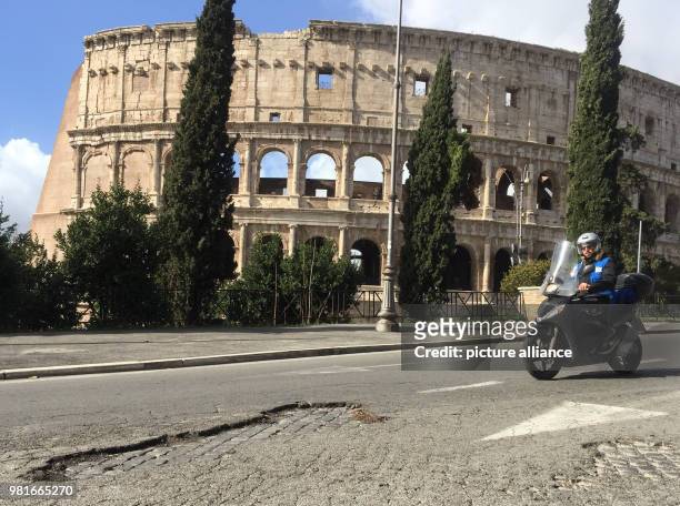March 2018, Italy, Rome: A pothole in front of the colloseum. Romes decline is legendary. But now prisoners have been put to the task of making the...
