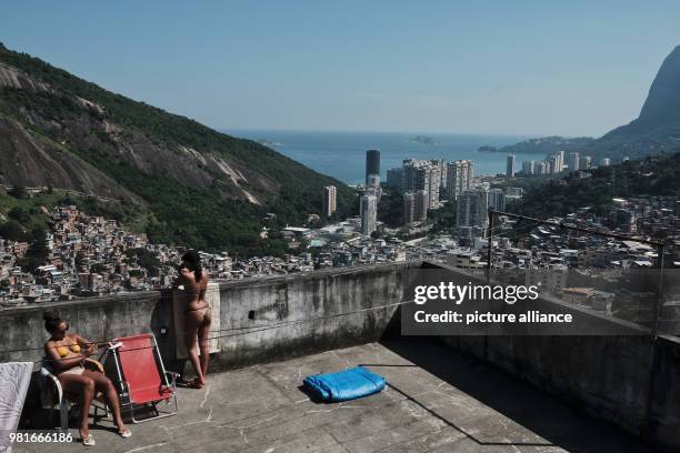 Two women sunbath on a terrace of a multi-story construction at the Rocinha favela in Rio de Janeiro, Brazil, 27 March 2018. Photo: Diego...