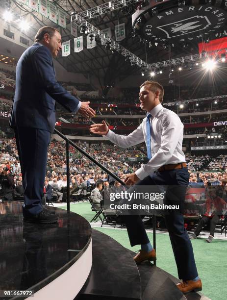 Ty Smith greets NHL commissioner Gary Bettman after being selected seventeenth overall by the New Jersey Devils during the first round of the 2018...