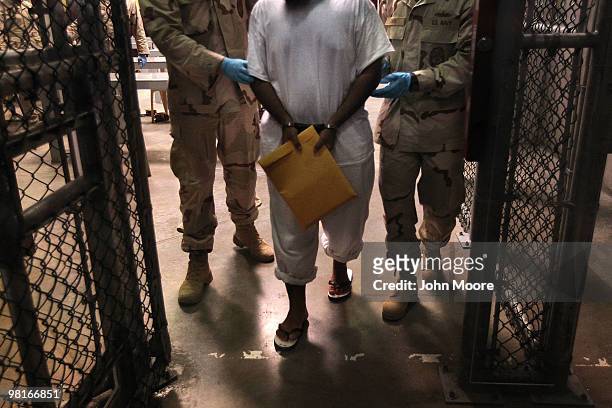 Navy guards escort a detainee after a "life skills" class held for prisoners at Camp 6 in the Guantanamo Bay detention center on March 30, 2010 in...