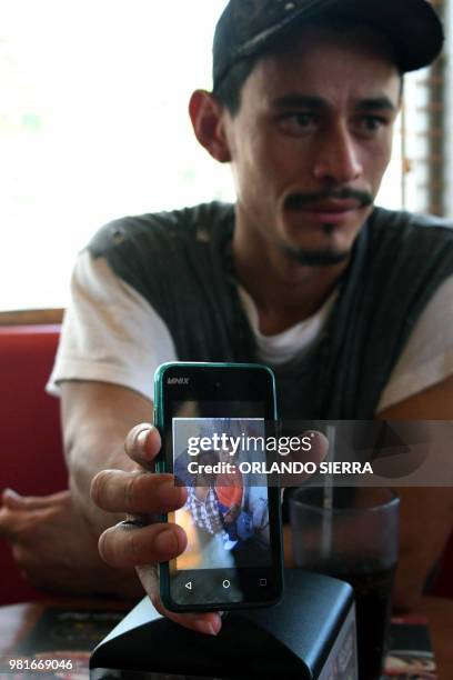 Honduran immigrant Ever Sierra who was deported from the US, shows a picture of his family, after arriving in San Pedro Sula, Honduras on June 22,...