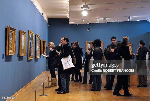 People look at paintings presented during the exhibition "Impressionism along the Seine" on March 31, 2010 in Giver, as part of the Normandie...