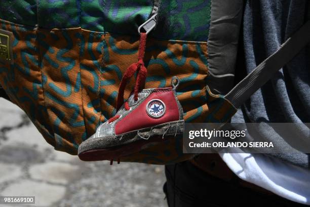 Little shoe that belongs to his baby girl hangs from the backpack of Honduran immigrant Ever Sierra who was deported from the US and arrived in San...