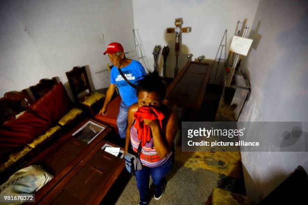 March 2018, Venezuela, Valencia: Mirian Rosa Oliveros tries to find her relatives between numerous coffins after a mutiny in a police station. At...