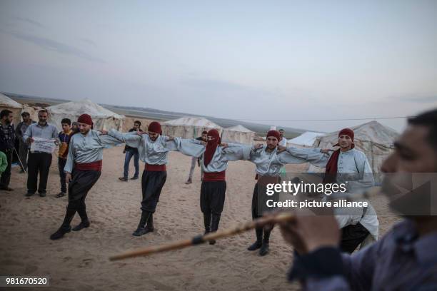 Dpatop - Palestinians perform the traditional Dabka dance next to tents installed ahead of a mass weeks-long protest, on the Gaza border with Israel,...