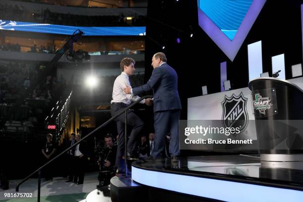 Quinton Hughes shakes hands wtih NHL commissioner Gary Bettman after being selected seventh overall by the Vancouver Canucksduring the first round of...