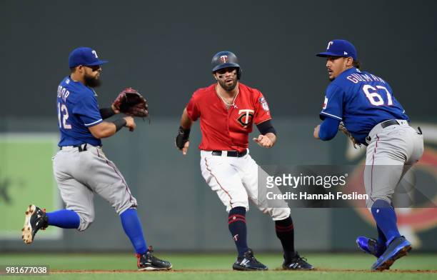 Ryan LaMarre of the Minnesota Twins is caught between first and second base by Rougned Odor and Ronald Guzman of the Texas Rangers during the sixth...
