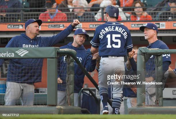 Cory Spangenberg of the San Diego Padres is congratulated by David Wells, manager Andy Green and coach Mark McGwire after Spangenberg scored against...
