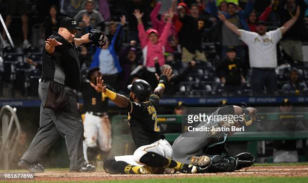 Gregory Polanco of the Pittsburgh Pirates reacts after he slid into home plate past Jeff Mathis of the Arizona Diamondbacks to score a run in the...