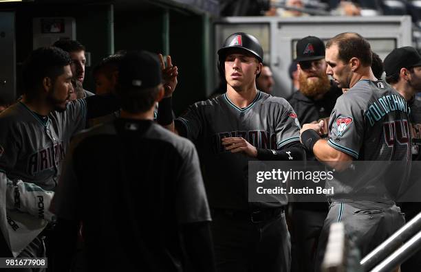 Jake Lamb of the Arizona Diamondbacks is greeted by teammates in the dugout after coming around to score in the eleventh inning during the game...
