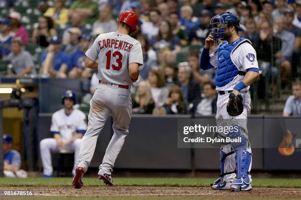 Matt Carpenter of the St. Louis Cardinals scores a run past Manny Pina of the Milwaukee Brewers in the third inning at Miller Park on June 22, 2018...