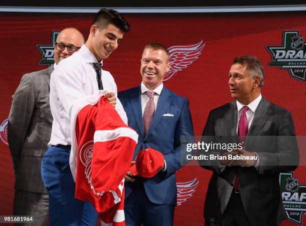 Joseph Veleno puts on a Detroit Red Wings jersey after being selected thirtieth overall by the Detroit Red Wings during the first round of the 2018...