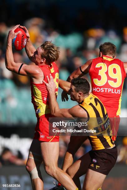 Tom Lynch of the Suns marks the ball against James Frawley of the Hawks during the round 14 AFL match between the Hawthorn Hawks and the Gold Coast...