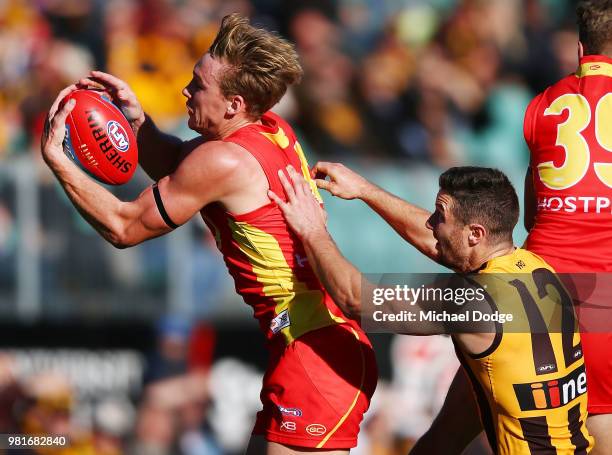 Tom Lynch of the Suns marks the ball against James Frawley of the Hawks during the round 14 AFL match between the Hawthorn Hawks and the Gold Coast...