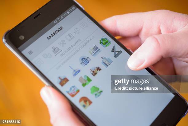 March 2018, Germany, Saarbruecken: The Saarmoji app open on a smartphone's display. The app containing the emojis from the Saarland has been...